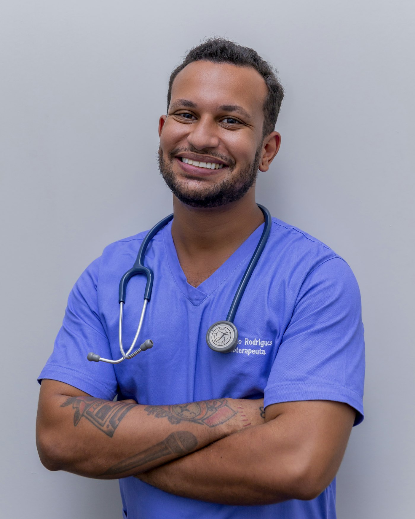 Male nurse in blue scrubs smiling